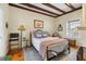 Comfortable bedroom with exposed ceiling beams, patterned rug and wrought iron bed frame at 2 Bedons Aly, Charleston, SC 29401
