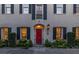 Elegant home with a red door framed by decorative windows, shutters, and manicured landscaping at 2 Bedons Aly, Charleston, SC 29401