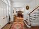 Inviting foyer featuring hardwood floors, a staircase, and a glimpse into the dining room at 2 Bedons Aly, Charleston, SC 29401