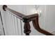 Close-up view of dark wood stair railing with white trim and detailed carvings at 2 Bedons Aly, Charleston, SC 29401