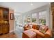 Bright sunroom with brick floors, a comfortable sofa, and a view of the courtyard at 2 Bedons Aly, Charleston, SC 29401