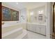 Large bathroom featuring a jetted tub, double vanity, tile flooring, and a window with natural light at 2 Wills Way, Isle of Palms, SC 29451