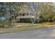 Quaint home exterior with mature trees offers a covered porch and a serene, landscaped setting at 2 Wills Way, Isle of Palms, SC 29451