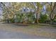 Two-story home with lush landscaping and a charming front porch and mature trees at 2 Wills Way, Isle of Palms, SC 29451