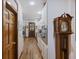 Hallway near kitchen with an antique grandfather clock, wooden floors, and direct view to the kitchen and dining area at 2 Wills Way, Isle of Palms, SC 29451