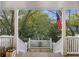View from the porch showcasing lush trees, and a glimpse of the neighborhood with an American flag at 2 Wills Way, Isle of Palms, SC 29451