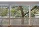 View from a porch with classic white railings showing lush green trees at 2 Wills Way, Isle of Palms, SC 29451