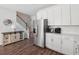Kitchen and stairway boast stainless steel appliances, hardwood floors, and modern cabinetry at 202 Kirkland St, Goose Creek, SC 29445