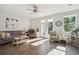 Sun-drenched living room with hardwood floors and access to the back patio through French doors at 202 Kirkland St, Goose Creek, SC 29445