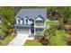 Aerial view of a charming home with double porches, garage, manicured lawn, and palm tree at 2111 Nicholas David Path, Johns Island, SC 29455