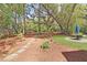 Landscaped backyard with patio table/chairs, pine straw, stone pathway and mature trees at 2111 Nicholas David Path, Johns Island, SC 29455
