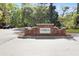 A brick sign welcomes residents into Waterloo Estates, accompanied by lush landscaping and a well-maintained roadway at 2111 Nicholas David Path, Johns Island, SC 29455