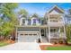 Exterior of the home featuring a two-car garage, double porches, well-maintained lawn, and landscaping at 2111 Nicholas David Path, Johns Island, SC 29455