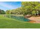 Picturesque pond surrounded by verdant lawn and trees provides a serene environment at 2111 Nicholas David Path, Johns Island, SC 29455