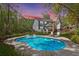 Backyard view featuring the home, in-ground pool, lounge chairs, and a well-manicured lawn surrounded by lush trees at 2111 Nicholas David Path, Johns Island, SC 29455