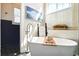 Luxurious bathroom showcasing a standalone tub, wainscoting, shuttered window, and natural light, creating a spa-like oasis at 225 Silverwood Ln, Summerville, SC 29485