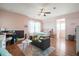 Bright bedroom with pink walls, hardwood floors, a bed, and a comfortable seating area with a dark gray sofa at 225 Silverwood Ln, Summerville, SC 29485