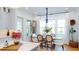 Bright dining area featuring hardwood floors and a stylish chandelier with water views through large windows at 2312 Rushland Landing Rd, Johns Island, SC 29455