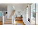 Bright foyer showcasing an open staircase, wood floors, and stylish decor; with views to living room at 2312 Rushland Landing Rd, Johns Island, SC 29455