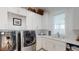 Well-lit laundry room with white cabinetry, stainless steel washer and dryer, and sink area at 2312 Rushland Landing Rd, Johns Island, SC 29455