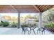 Relaxing outdoor patio with wood-beam ceiling, overlooking greenhouse and landscaped yard at 2312 Rushland Landing Rd, Johns Island, SC 29455