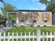 Charming home featuring three windows with stylish shutters, complemented by a white picket fence and a well-manicured lawn at 2313 Kent Ave, North Charleston, SC 29405
