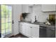Bright kitchen has white cabinets, stainless appliances, subway tile backsplash, and backyard views at 2313 Kent Ave, North Charleston, SC 29405