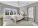 Bright bedroom features a large window, neutral carpet, a ceiling fan, and stylish décor at 2340 Salt Wind Way, Mount Pleasant, SC 29466