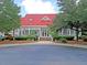 Exterior view of clubhouse featuring a red roof, white siding and professionally landscaped entrance at 2340 Salt Wind Way, Mount Pleasant, SC 29466