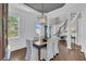 Open-concept dining room showcasing a dark wood table with seating, a decorative chandelier, and views of the staircase and foyer at 2340 Salt Wind Way, Mount Pleasant, SC 29466