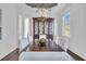 Elegant dining room featuring a dark wood table with white upholstered chairs, a stylish hutch, and ample natural light at 2340 Salt Wind Way, Mount Pleasant, SC 29466