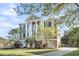 Stately three-story home featuring a manicured lawn, grand white columns, and a private drive at 2340 Salt Wind Way, Mount Pleasant, SC 29466