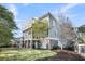 Back exterior shows a multi-story house with screened in porch and balcony overlooking a yard at 2340 Salt Wind Way, Mount Pleasant, SC 29466
