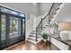 Inviting foyer boasts hardwood floors, staircase with iron railings, wainscoting, and a stylish console table with décor at 2340 Salt Wind Way, Mount Pleasant, SC 29466