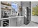 Contemporary laundry room featuring gray cabinets, marble countertops, stylish backsplash, beverage cooler, and stacked washer/dryer at 2340 Salt Wind Way, Mount Pleasant, SC 29466