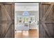 Inviting living room with vaulted ceilings, hardwood floors, white sofa and French doors leading to the backyard at 2340 Salt Wind Way, Mount Pleasant, SC 29466