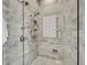 Luxurious walk-in shower with multiple shower heads, white marble tiling, and mosaic tile accent for a spa-like experience at 2340 Salt Wind Way, Mount Pleasant, SC 29466