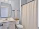 Bright bathroom with white vanity, rectangular mirror, toilet and shower with neutral colored curtain at 2823 Dearmin Dr, Mount Pleasant, SC 29466