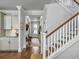 Hallway view showcasing the staircase and kitchen, leading towards a bright entryway with a bench at 2823 Dearmin Dr, Mount Pleasant, SC 29466