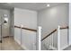 Upstairs hallway with carpet, wooden railing, and a view of the stairwell and doors to other rooms at 2823 Dearmin Dr, Mount Pleasant, SC 29466