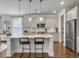 Spacious kitchen featuring an island, stainless steel fridge, white cabinets, counter seating, and stylish pendant lights at 2823 Dearmin Dr, Mount Pleasant, SC 29466