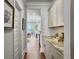 Hallway view into kitchen with white cabinets and granite countertop, leading to a bright dining area at 2823 Dearmin Dr, Mount Pleasant, SC 29466