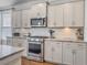 Well-lit kitchen with stainless steel microwave, oven, white cabinets, granite counters, and subway tile backsplash at 2823 Dearmin Dr, Mount Pleasant, SC 29466