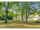 Expansive backyard shaded by mature trees, featuring a swing set and ample space for recreation at 301 Huntington Ct, Hanahan, SC 29410