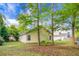 Scenic backyard view featuring mature trees, the home's exterior, and a swing set, perfect for families at 301 Huntington Ct, Hanahan, SC 29410