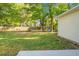 Spacious backyard featuring lush green grass, mature trees, and a swing set for outdoor enjoyment at 301 Huntington Ct, Hanahan, SC 29410