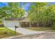 Well-kept single-story house featuring beautiful landscaping, mature trees, and a convenient two-car garage at 301 Huntington Ct, Hanahan, SC 29410