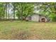 Wide view of the backyard showcasing lush greenery, a shed, and a partially fenced perimeter at 306 Fairlawn Drive, Moncks Corner, SC 29461