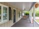 Inviting front porch with a swing and dark wood flooring providing a relaxing outdoor space at 306 Fairlawn Drive, Moncks Corner, SC 29461
