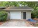 Exterior view of the garage featuring a white door and a side entry, complemented by the surrounding trees at 306 Fairlawn Drive, Moncks Corner, SC 29461